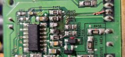 Zbliżenie uszkodzonej płytki PCB z widocznymi oznaczeniami elementów i przypaleniami