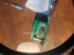 Close-up of an SM-028_V1.3 electronic module held in a servicing clip.