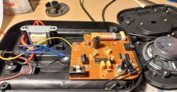 Open electronic device with visible circuit board and electronic components.
