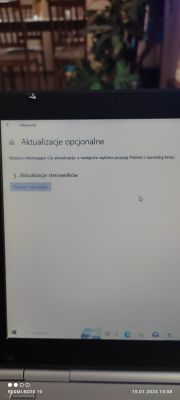 Ekran laptopa z niezaktywną opcją 'Pobierz i zainstaluj' w ustawieniach aktualizacji opcjonalnych.