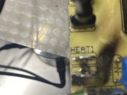 Zbliżenie na płytkę elektroniczną z oznaczeniem HEAT1 i widocznymi przypaleniami.