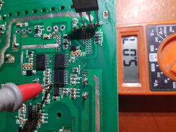 Voltage measurement on a circuit board using a multimeter.