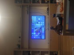 Telewizor na regale z widocznymi białymi kropkami na ekranie.