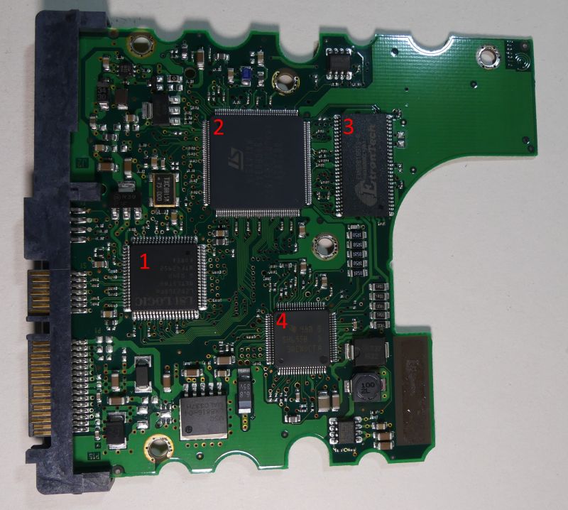Hard disk drive circuit board with four marked integrated circuits.