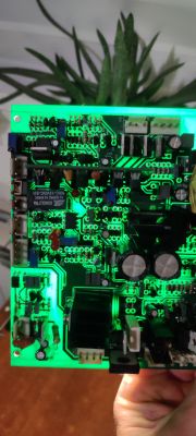 Płyta PCB z elementami elektronicznymi, podświetlona od tyłu na zielono