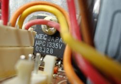 Zbliżenie na wewnętrzne części elektroniczne z kablami i układem scalonym NEC.