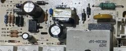 Fragment płytki PCB z elementami: transformator, kondensatory, diody i układ scalony w obudowie DIP-8.