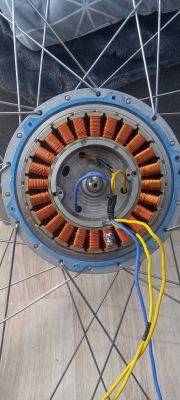 Silnik elektryczny z widocznymi uzwojeniami miedzianymi i przewodami.