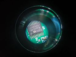 Microscopic close-up of an integrated circuit on a green PCB