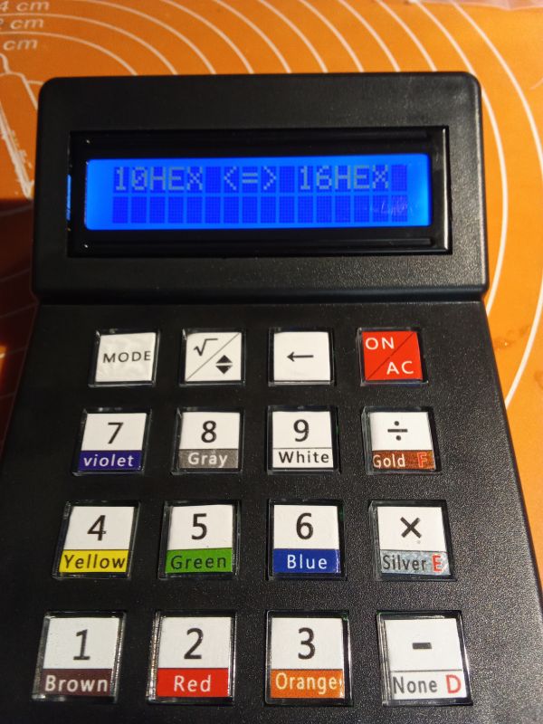 Kalkulator elektroniczny z wyświetlaczem i kolorowymi przyciskami.