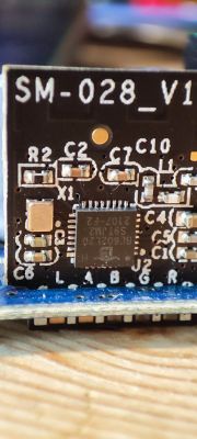 Close-up of a circuit board labeled SM-028_V1 with integrated circuits and other electronic components.