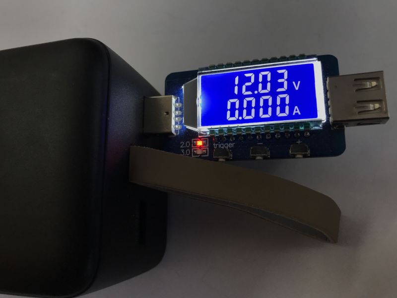 Powerbank connected to a voltage meter displaying 12.03V and 0.000A.
