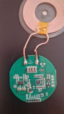 Zielona płytka elektroniczna ładowarki indukcyjnej z cewką miedzianą i złączami.