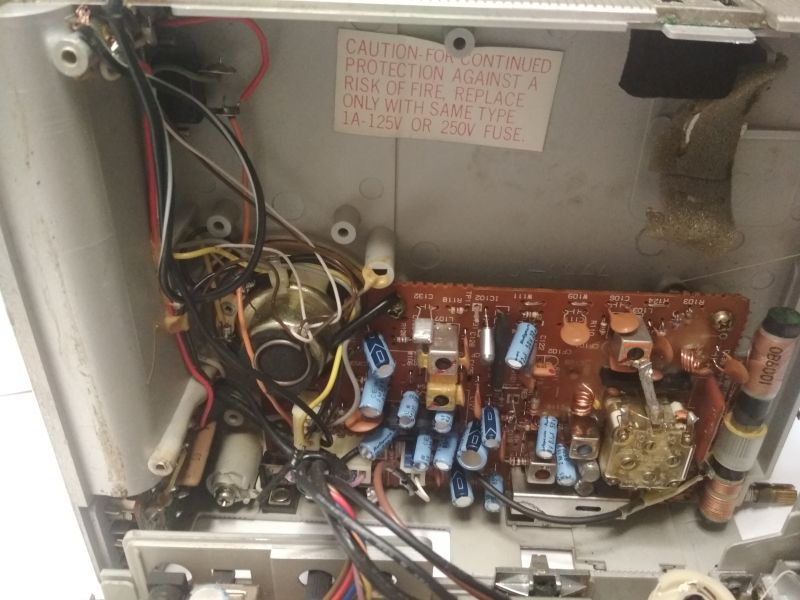 Wnętrze urządzenia elektronicznego z widocznymi przewodami i podzespołami.