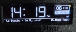 Digital clock display with music and date information.