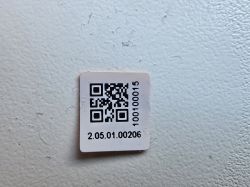 Label with QR code and serial number on a light background.