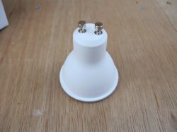 White GU10 Bulb Socket White GU10 bulb socket on a wooden background.