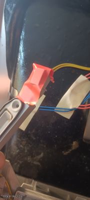 Zbliżenie na czujnik z czerwonym magnesem przyklejonym taśmą do metalowej powierzchni