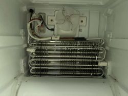 Wnętrze zamrażarki z widocznym parownikiem, wentylatorem i przewodami elektrycznymi
