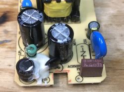 Power Supply PCB with Filtering Elements Close-up of a power supply PCB showing capacitors, coils, and protective components.