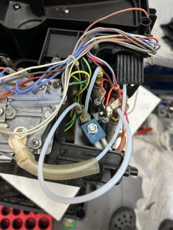 Wnętrze urządzenia z widocznymi kablami, rurkami i podzespołami elektrycznymi