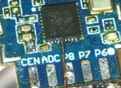 Close-up of a CB2S module PCB with a thin wire soldered to a QFN pin.