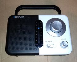 Przenośne radio marki Blaupunkt z uchwytem i pokrętłami do regulacji.