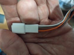 Zbliżenie białej wtyczki z czterema przewodami Białe złącze elektryczne z czterema przewodami trzymane w dłoniach, zbliżenie