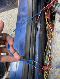 Soldered Connections in Car Wiring Harness Close-up of a car wiring harness with manually soldered blue and red wires.