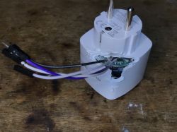 View of a modified electrical plug with exposed wires and PCB.