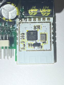 Close-up of an electronic component with a visible integrated circuit and capacitors.
