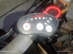 Panel sterowania na kierownicy fatbike'a z różnymi przyciskami i wskaźnikami.