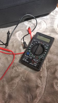 Cyfrowy miernik DT-832 z przewodami pomiarowymi na dywanie