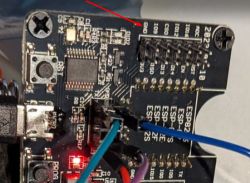 Close-up of a circuit board with a GND connector marked with a red arrow. The board contains various electronic components and connectors.