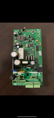 Elektroniczna płytka sterownika bramy z elementami montażowymi.