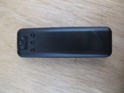 Mini spy camera with black casing and clip Black mini spy camera with clip on wooden surface