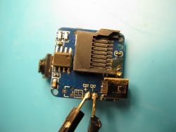 Inside View of SQ11 Mini Camera with Flash Memory Chip Close-up of a circuit board with a microSD slot and flash memory chip.