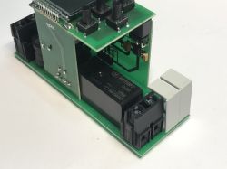 Płytka drukowana z elementami elektronicznymi, przekaźnikiem i złączami podłączeniowymi.
