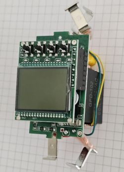 Electronic module with LCD screen and buttons on a grid paper background