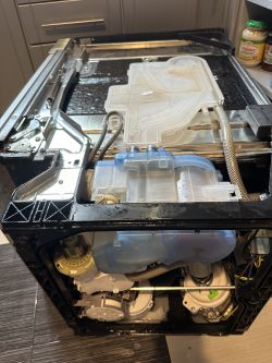 Wnętrze zmywarki Whirlpool ADG 689 IX z ujawnioną częścią, z której cieknie woda.