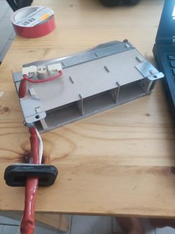 Moduł grzewczy suszarki Electrolux leżący na drewnianym stole