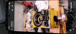 Zdemontowany korpus pompy hydraulicznej żurawia warsztatowego żółty korpus pompy hydraulicznej z widocznymi zaworami i pokrętłem