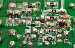 Zbliżenie na płytkę PCB z uszkodzeniami, zaznaczony jeden z komponentów SMD