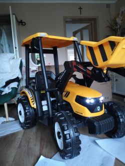 Żółty elektryczny traktorek dziecięcy z napisem „TRACTOR” i działającymi światłami LED.