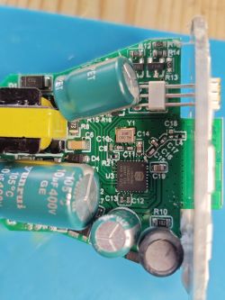 Close-up of a PCB with electrolytic capacitors, resistors, an inductor, and an integrated circuit.