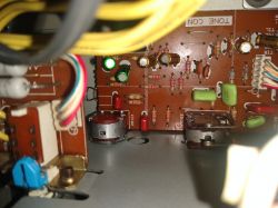 Wnętrze urządzenia elektronicznego z płytką drukowaną i elementami takimi jak rezystory i kondensatory.