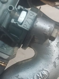 Zbliżenie na połączenie gaźnika PZ19 z kolektorem dolotowym w motocyklu Loncin 110, z widoczną nieszczelnością.