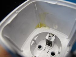 Interior of an Electrical Socket Interior of an electrical socket housing with glue and a mounting screw.