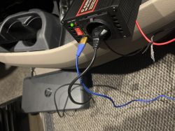 Adapter samochodowy podłączony w samochodzie, ładuje inne urządzenia.