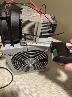 Wentylator i radiator przymocowane do zasilacza z kablami i miernikiem